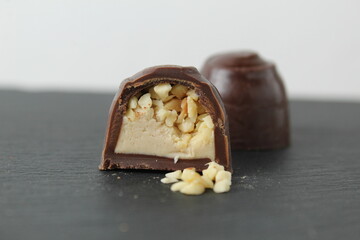 Canvas Print - chocolate case candy in section with praline peanuts crushed on a gray background close-up. A day of chocolate without a diet