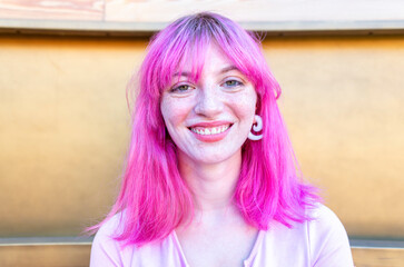close up portrait of alternative woman withpink hair hanging out chilling and smiling standing isola