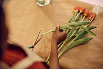 Wall Mural - Close up of florist making bouquet of tulips at flower shop.