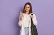 © sementsova321 - Indoor shot of sad depressed woman with black bag wearing white shirt and jeans posing isolated over purple background, standing with cell phone in hands and crying, having bad news.