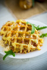 Wall Mural - fried potato waffles with cheese in a plate on wooden table.