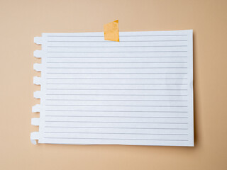 Blank sheet of paper with stripes taped on a beige background