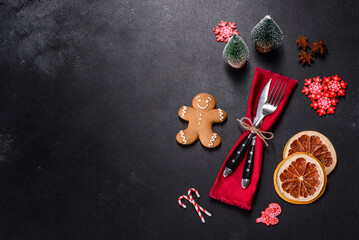 Christmas table setting with empty black ceramic plate, fir tree and black accessories