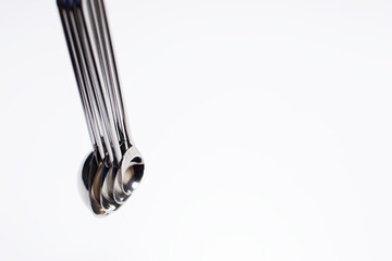 Studio picture of a small set of chromatic measuring spoons, kitchen equipment.