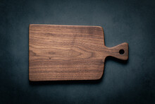 A Handcrafted Black Walnut Wood Chopping Board Sits On A Dark-toned Tabletop. Walnut Wood Board.