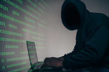 Wall Mural - The hacker was wearing a black hoodie. Stealing huge financial data on computers with binary code digital interface and lots of falling dollars and lying on the table.Hacking and malware concept.