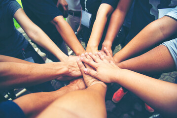 Wall Mural - Teamwork Hands of spirit team working together outdoor. Unity strong handshake with people or agreement of feeling or happy diverse education action