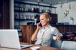 © Dusan Petkovic - A happy businesswoman sits in a working friendly cafe and having an important call.
