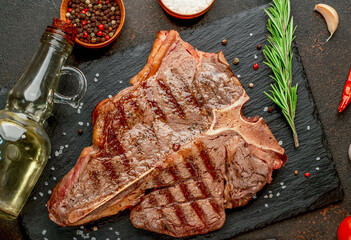 Wall Mural - grilled T-bone steak or porterhouse Steak with herbs and salt on stone background