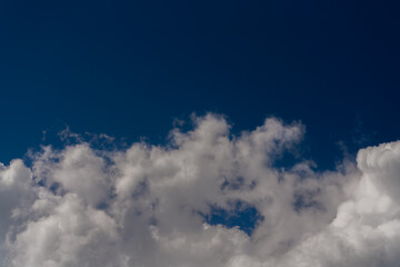 Wall Mural - Beautiful white clouds on a bright blue background.