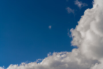 Wall Mural - Beautiful white clouds on a bright blue background.