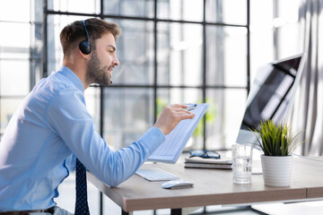 Sticker - Young man is working with papers while sitting in the office. Successful entrepreneur is studying documents with attentive and concentrated look.