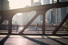 Side View Of Man On The Move While Walking On Bridge And Looking Around. City In Morning Light. .