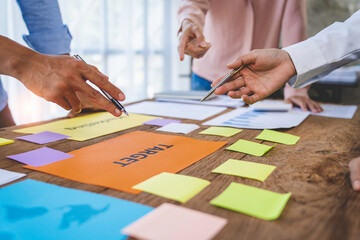 Business people meeting at office and use sticky notes on glass wall in office, diverse employees people group planning work together brainstorm strategy.