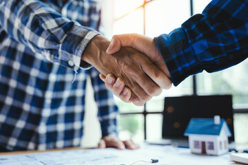 Architect and engineer construction workers shaking hands while working for teamwork and cooperation concept after finish an agreement in the office construction site, success collaboration concept