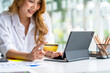 © crizzystudio - Young smiling asian woman resting and shopping online at home, Happy woman using laptop and credit card for online shopping. Online payment concept.