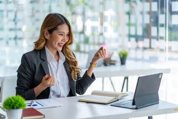 Beautiful of portrait an Asian young businesswoman excited and glad of success with a laptop computer