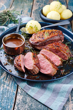 Traditional Barbecue Gourmet Duck Breast Filet With Skin Served With Dark Beer Sauce As Close-up On A Rustic Plate