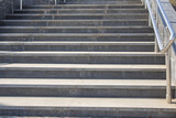 Fototapeta  - Outdoor concrete steps on a modern city staircase with metal railings on a sunny day, outdoors, bottom view
