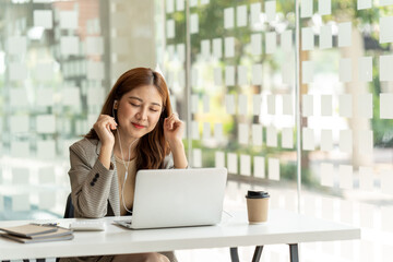 Young beautiful woman using her laptop while sitting in a chair at her working place,  Small business owner people employee freelance online sme marketing e-commerce telemarketing concept.