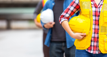 engineer team hold hardhat, safety helmet, for safety teamwork job at construction site in business industrial