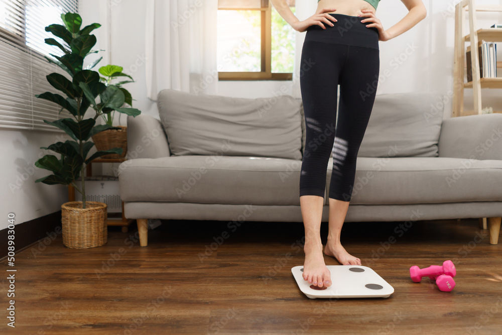 Healthy and weight loss concept, Young Asian woman stepping on weighing ...