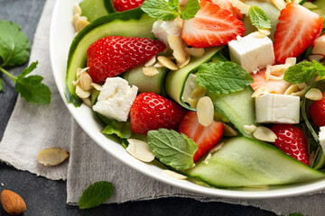 Summer Strawberry, cucumber salad with lettuce, feta cheese and almonds. Healthy Food.