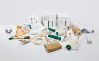 house painter tools, brushes, paint rollers, paper masking tape and colors swatches on blueprint with model house, supply and service in color shop in the hardware and store of building material.