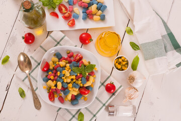 Colored gnocchi with vegetables and sweet corn.