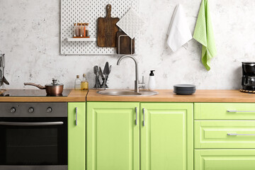 Canvas Print - Interior of modern kitchen with green furniture, sink and electric stove