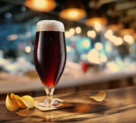 Wall Mural - Cooled glass of dark beer on the wooden table. Blurred pub interior at the background.