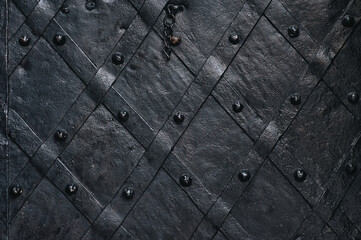 old forged black metal door with stripes and rivets of the boim chapel in lviv, ukraine. vintage bac