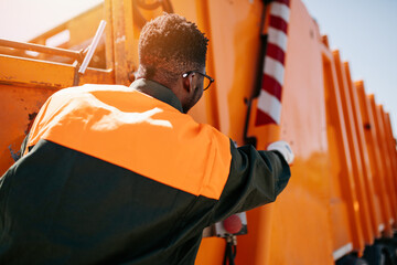 African American worker of the city utility company on his job. Garbage collector.