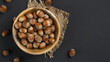 hazelnuts on a dark matte gray background close-up in a wooden plate, close-up, tom view, copy space