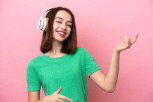 Young Ukrainian Woman Isolated On Pink Background Listening Music And Doing Guitar Gesture