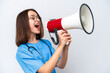 © luismolinero - Young nurse Ukrainian woman isolated on white background shouting through a megaphone