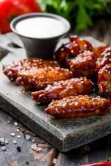 Poster - chicken wings in barbecue sauce with sesame extreme macro close up vertical on wooden table