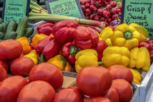 Producevegetables For Sale At A Market Stand With Tomatoes, Yellow And Red Peppers, Cucumbers, Rhubarb, Radishes, Daytime, Nobody