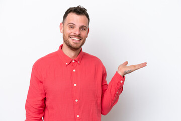 Wall Mural - Young Brazilian man isolated on white background holding copyspace imaginary on the palm to insert an ad