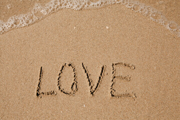 Wall Mural - Love - handwritten on the soft beach sand.