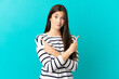 © luismolinero - Teenager Brazilian girl over isolated blue background pointing to the laterals having doubts