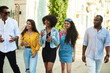 © etonastenka - College students walking together outdoors. Young beautiful people of different nationalities walk around the city and talk
