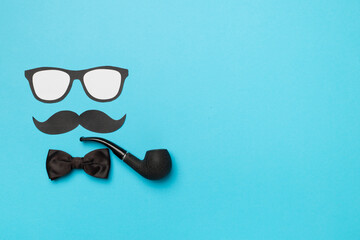 Wall Mural - Glasses, mustache and bow tie on color background, top view. Happy Father's Day concept