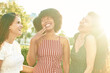 © etonastenka - Three beautiful smiling girlfriends. Multi ethnic group of women staying outdoors by the city street and smiling