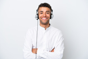 Wall Mural - Telemarketer Brazilian man working with a headset isolated on white background keeping the arms crossed in frontal position