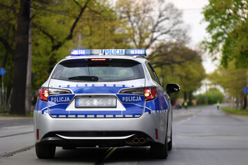 Wall Mural - Radiowóz polskiej policji w mieście podczas patrolu na sygnale alarmowym. 