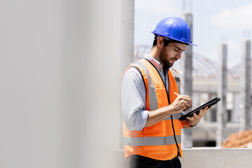 a portrait of an industrial man engineer with smartphone in a site house, working.