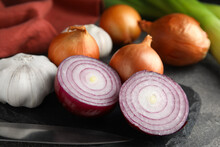 Fresh Whole And Cut Onions, Leek, Garlic On Grey Table, Closeup