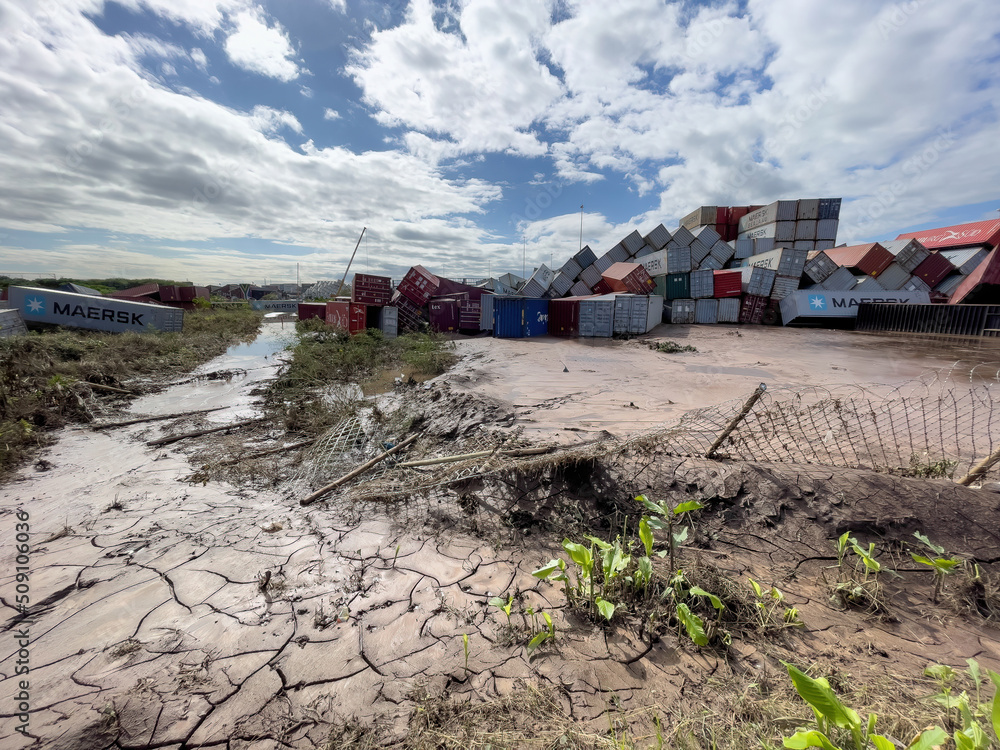 Fallen shipping containers lying in deep mud and water after heavy ...