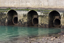Sewer Pipes With Waste Flowing Into A Waterway
